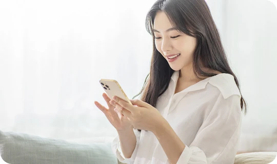 스마트폰을 보며 정보를 검색하는 여성